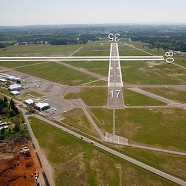 Olympia Regional airport runway located in a middle of a large wide open grass area.