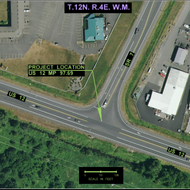 arial view of two intersecting roads in a T shape with green trees adjacent to the roadway