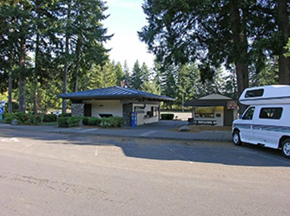 Rest area building near a parking lot surrounded by trees