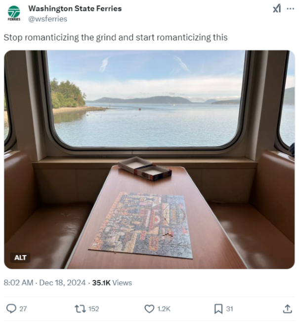 Screenshot of Dec. 18 Washington State Ferries X post of a puzzle on a table aboard a ferry with a scenic view out the window and text, "Stop romanticizing the grind and start romanticizing this"