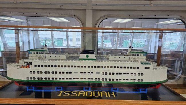 Lego model of a white and green ferry named "Issaquah" displayed in a case