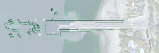 Aerial view of a coastal area with a pier overlayed with green lines and shapes, next to the road labeled "Fauntleroy Way SW"